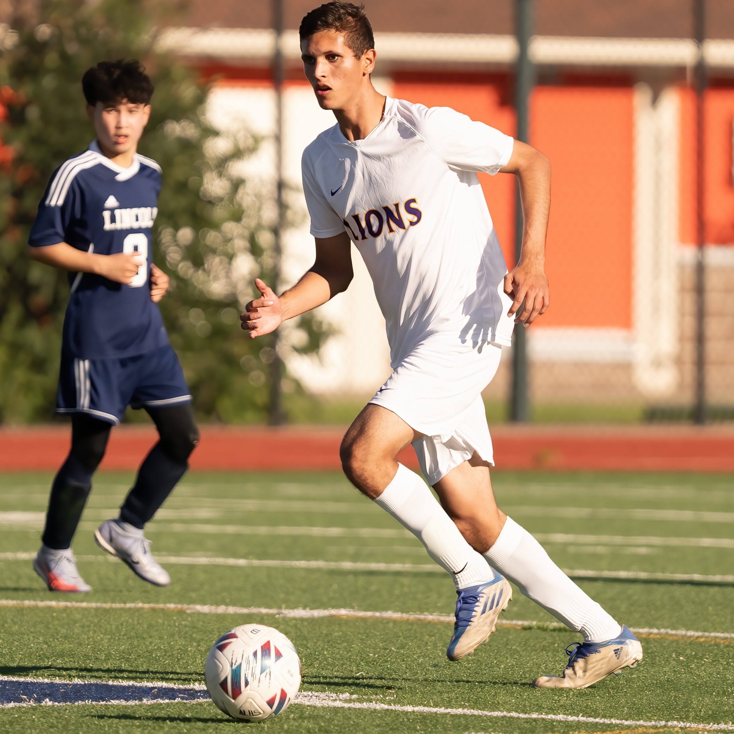 Marconi Porra running to kick a soccer ball during a LHS soccer game.